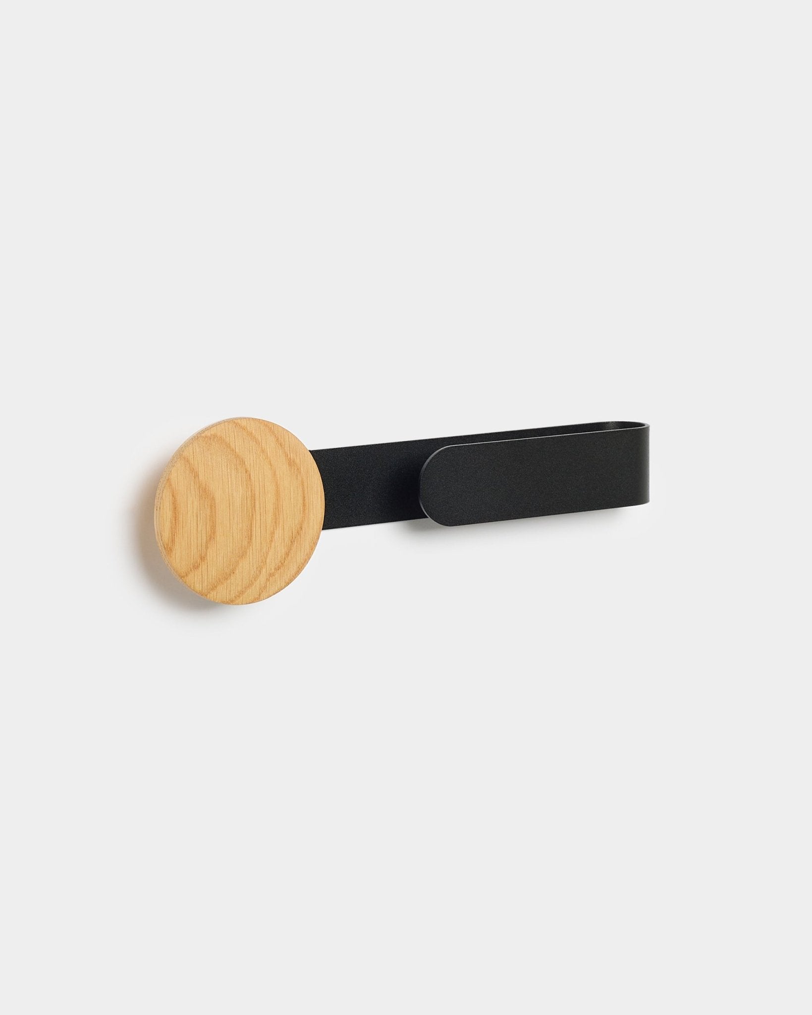 Linn Horizontal Hanger de WoodUpp avec une patère en natural oak et un bras en métal black, conçu pour compléter votre Akupanel Panneau acoustique.